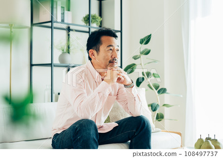 A middle-aged man relaxing in the living room 108497737
