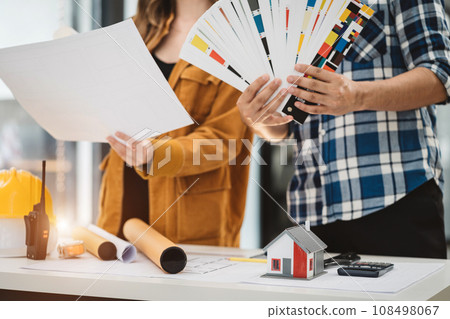 Two colleagues discussing data working and tablet, laptop with on on architectural project at construction site at desk in office. Two colleagues discussing data working and tablet, laptop with on on architectural project at construction site at desk in office. 108498067