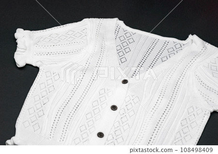 close up to flat White knitwear tshirt shape on black background with studio light. close up to flat White knitwear tshirt shape on black background with studio light. 108498409