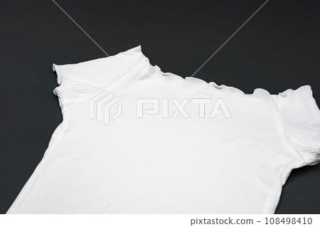 close up to flat White knitwear tshirt shape on black background with studio light. close up to flat White knitwear tshirt shape on black background with studio light. 108498410