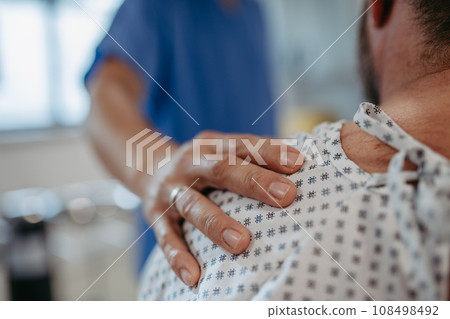 Close up of supportive doctor soothing a worried overweight patient, discussing test result in emergency room. Illnesses and diseases in middle-aged men's health. Compassionate physician supporting 108498492