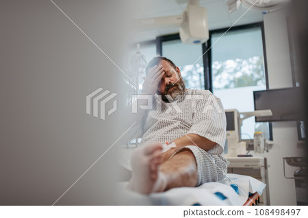 Overweight patient in hospital gown waiting for medical examination, test results in hospital, feeling anxious. Patient feeling dizzy, have vertigo and intense pain. 108498497