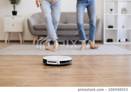 Cleaning robot dusting off floor when young couple moving to music 108498933