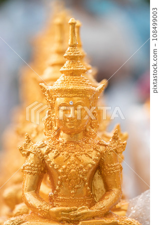 Golden Buddha statues placed on the white table, which were wet by rain felled and prepared for a religion ceremony event. 108499003