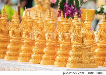 Golden Buddha statues placed on the white table, which were wet by rain felled and prepared for a religion ceremony event. Golden Buddha statues placed on the white table, which were wet by rain felled and prepared for a religion ceremony event. 108499008