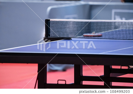 Blue and smooth surface table tennis table with tight black net to being prepared for practice and competition. 108499203