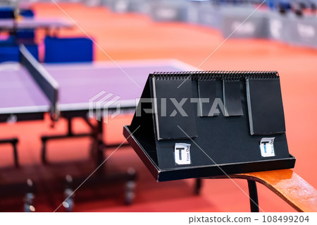 A tennis table black scoreboard is placed next to the table tennis table for referee count the score, which acts as a blurred background of pingpong tournament. 108499204