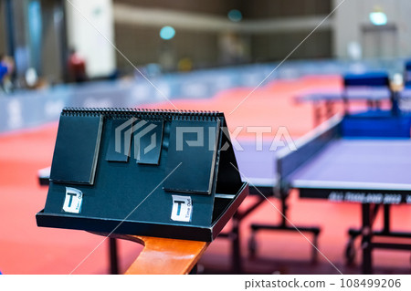 A tennis table black scoreboard is placed next to the table tennis table for referee count the score, which acts as a blurred background of pingpong tournament. 108499206