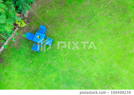 Top view of the blue chair and table in the grass field garden in relax background. Top view of the blue chair and table in the grass field garden in relax background. 108499239