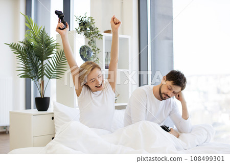 Caucasian couple in love have fun competing in laptop game using joysticks 108499301