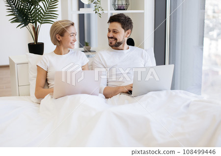 Amorous people spending time together using laptop in bed Amorous people spending time together using laptop in bed 108499446