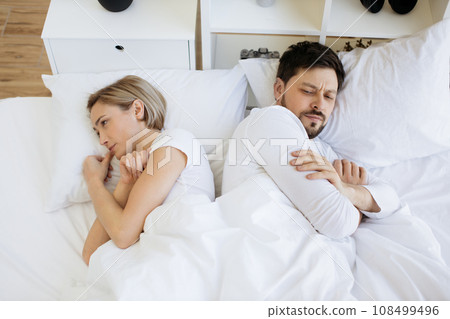 Offended caucasian woman lying on white pillow covered with a blanket. Offended caucasian woman lying on white pillow covered with a blanket. 108499496