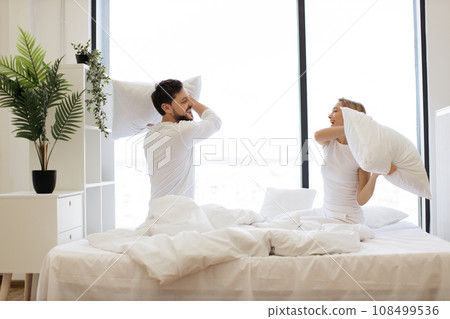 Young passionate Caucasian couple fighting with pillows 108499536