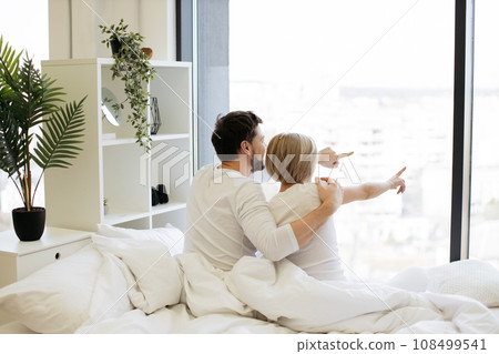 Back view of loving caucasian couple in casual attire hugging after night sleep 108499541
