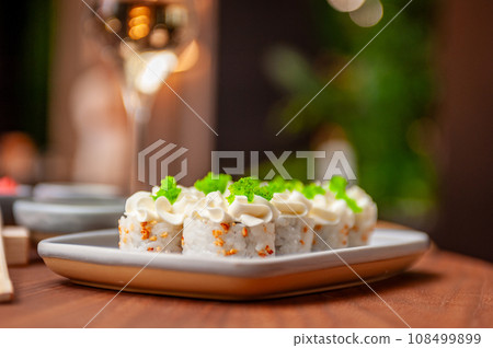 Sushi roll with cream cheese, sesame seeds and green flying fish caviar 108499899