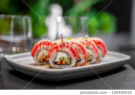 Sushi roll with tuna, cream cheese, cucumber and curry sauce on a plate Sushi roll with tuna, cream cheese, cucumber and curry sauce on a plate 108499916