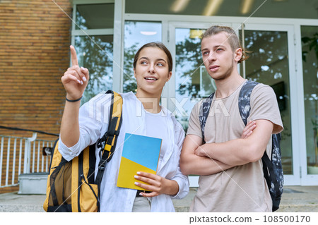 Meeting of two teenage students, guy and girl, near educational building 108500170