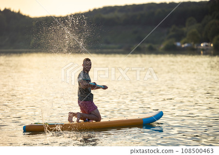 Man on the supboard on the middle of the lake. 108500463