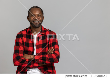 Confident happy black bearded man wearing red checkered shirt crossed hand looking at camera 108500642