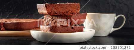 Chocolate brownie with tea panorama, simple coffee cake, a side view Chocolate brownie with tea panorama, simple coffee cake, a side view 108501271