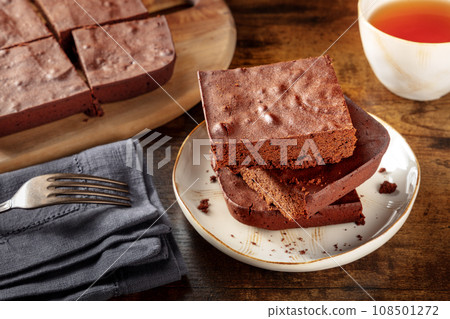 Chocolate brownie with tea, simple coffee cake, on a dark rustic table Chocolate brownie with tea, simple coffee cake, on a dark rustic table 108501272