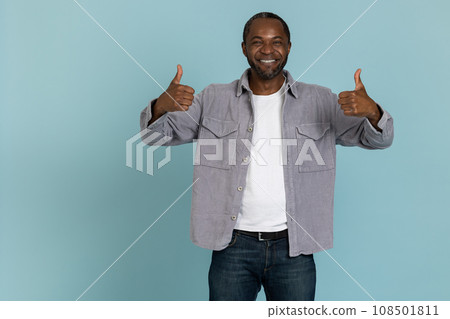 Smiling black man wearing gray shirt showing thumb up Smiling black man wearing gray shirt showing thumb up 108501811