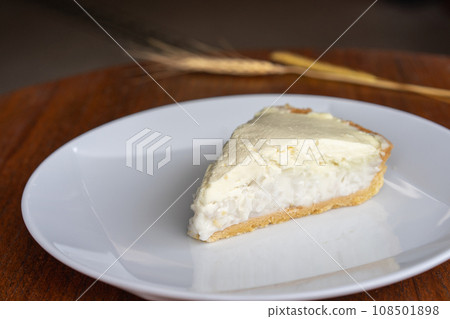 Clear Coconut Cream Pie in the dish on the wood table without anything topping on it. Shooting in the sunlight. 108501898