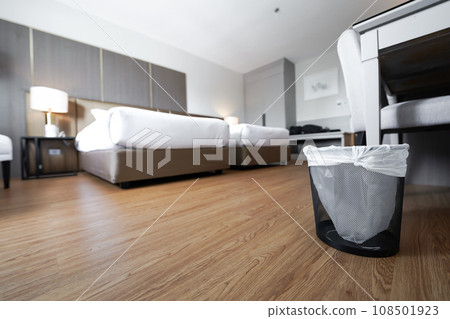A container trash in the room with plastic inside it in hotel and resort bedroom with wooden floor and furniture background. A container trash in the room with plastic inside it in hotel and resort bedroom with wooden floor and furniture background. 108501923