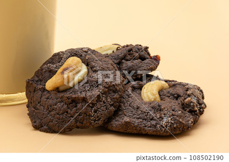 Dark Chocolate Cookies with raisin inside it on the light orange colour background. Dark Chocolate Cookies with raisin inside it on the light orange colour background. 108502190