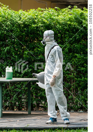 Professional technical man in prevention suit with his sterilizing machine and disinfecting water. He is ready to take purifying coronavirus (COVID-19) out. 108502258