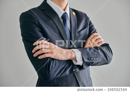 A male lawyer stands with his arms folded against a white background A male lawyer stands with his arms folded against a white background 108502584