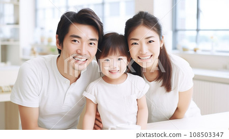 A little girl and her parents smiling in a bright white room 108503347