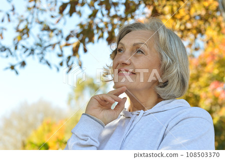 Senior woman walking in the park in autumn.  108503370