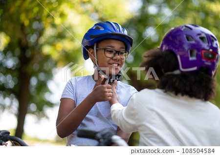 Sister helping her brother to fix the protective hemlet 108504584