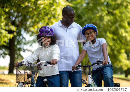 Father and children spending time in a park together 108504717