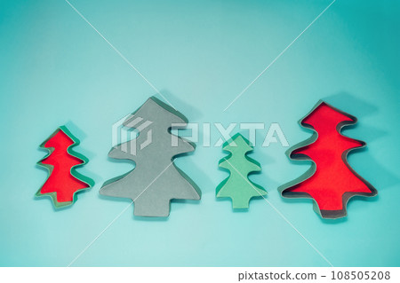 Top view empty Christmas gift boxes in the shape of Christmas trees on the turquoise background. Craft gift box packaging ideas. Christmas presents delivery service. Flat lay, copy space. 108505208