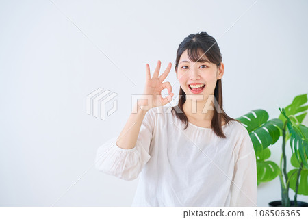 一個年輕的女人給出一個好的手勢 一個年輕的女人給出一個好的手勢 108506365