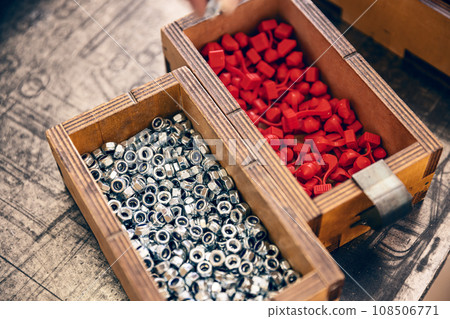 Metal nut with metric thread in wooden box Metal nut with metric thread in wooden box 108506771