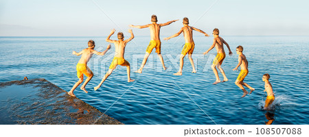 Sequence of jump. Moments of schoolboy jumping from pier into sea doing tricks 108507088