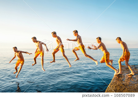 Sequence of jump. Moments of schoolboy jumping from pier into sea doing tricks Sequence of jump. Moments of schoolboy jumping from pier into sea doing tricks 108507089