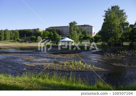 View of the park with a shallow river in the city of Petrozavodsk on a summer evening View of the park with a shallow river in the city of Petrozavodsk on a summer evening 108507104