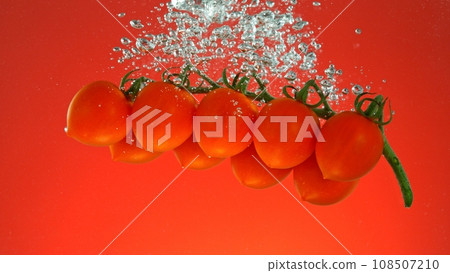 Cherry Tomatoes Falling into Water. 108507210