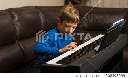 Focused Boy Playing Piano 108507969