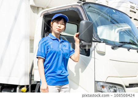 Young female driver standing in front of the truck Young female driver standing in front of the truck 108508424