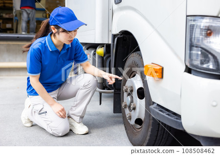 Young female driver performing pre-work inspection of truck 108508462