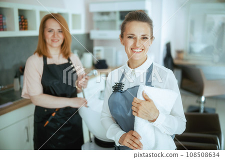 happy two hair salon employees in aprons in hair studio 108508634
