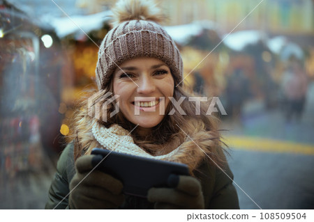 smiling young female at christmas fair in city 108509504