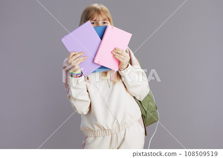 trendy teenage girl with backpack peeking out of notebooks trendy teenage girl with backpack peeking out of notebooks 108509519