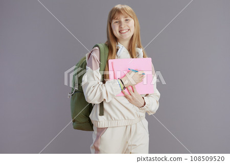 Portrait of smiling modern teenage girl in beige tracksuit 108509520
