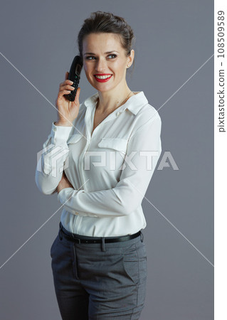 smiling woman worker talking on old radio phone against grey smiling woman worker talking on old radio phone against grey 108509589